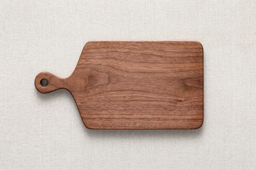Walnut handmade wood cutting board on the linen