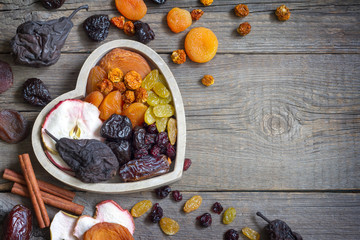 Dried fruits on wooden board in the heart food concept
