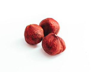 Three brown raw hazelnuts, isolated on white background.
