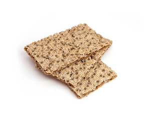 A pile of three crunchy wheat rye brown crackers, isolated on white background. Healthy food concept.