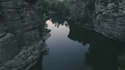 Narrow brook flowing between two stony rocks in the evening in summer