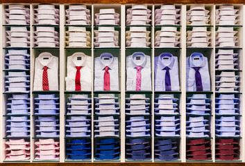 Showcase with many various colorful folded male fashion shirts for adult collection in stock on...