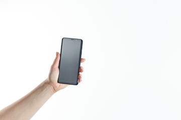 Female hand holding black cellphone with white screen.