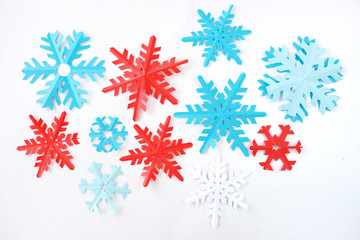 snowflakes from paper of blue and red color on a white background