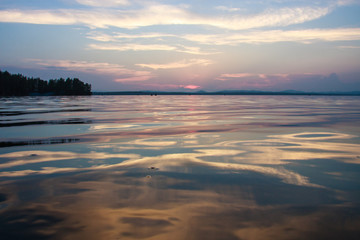Obraz premium very beautiful sunset on the lake. beautiful natural background. blue and pink clouds with reflection from water.