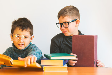 two boys with glasses reading books