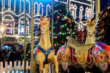 Colorful carousel before Christmas on the Red square of the Kremlin. Fabulous, night lighting, walking people.