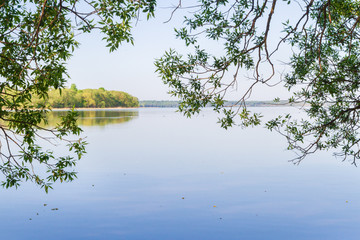 Fototapeta na wymiar Вид из леса на красивое большое озеро поздней весной