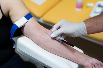 Blutentnahme , das Blut fließt ins Röhrchen