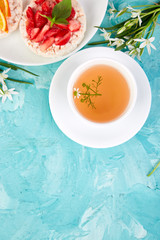 Breakfast - tea, rice crispbread with fresh fruits on blue background.