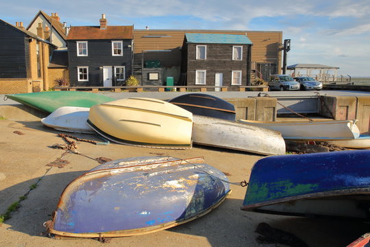 Traditional timber houses located at Strand Wharf, with colorful boats in the foreground, Leigh on Sea, UK