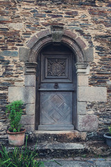 Ancient door. Old vintage rustic wooden door in French village.