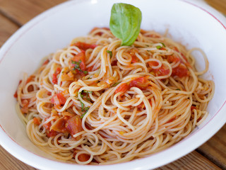 Spaghetti napolitain, pasta with tomato sauce and basil garnish