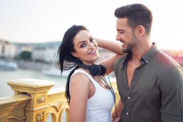 Happy young urban couple with headphones at outdoors