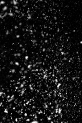 Falling snow on a black background. Snowfall weather. Texture for overlay