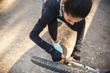 Attractive fit sportswoman having to fix her bicycle at the park