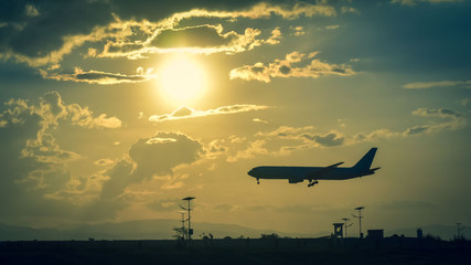 landing of the plane on the airfield against the bright sun and beautiful cloudy sky