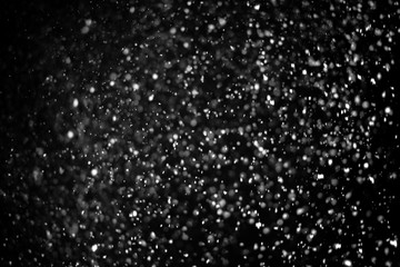 Falling snow on a black background. Snowfall weather. Texture for overlay