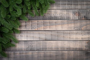 Christmas background concept. Top view of spruce branches with snow and pine cones, on old wooden background.