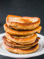 Stack of small pancakes with banana and chia seeds on black background. Pancake with chia or poppy seeds.