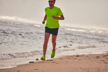 Man running / jogging on a tropical exotic beach.