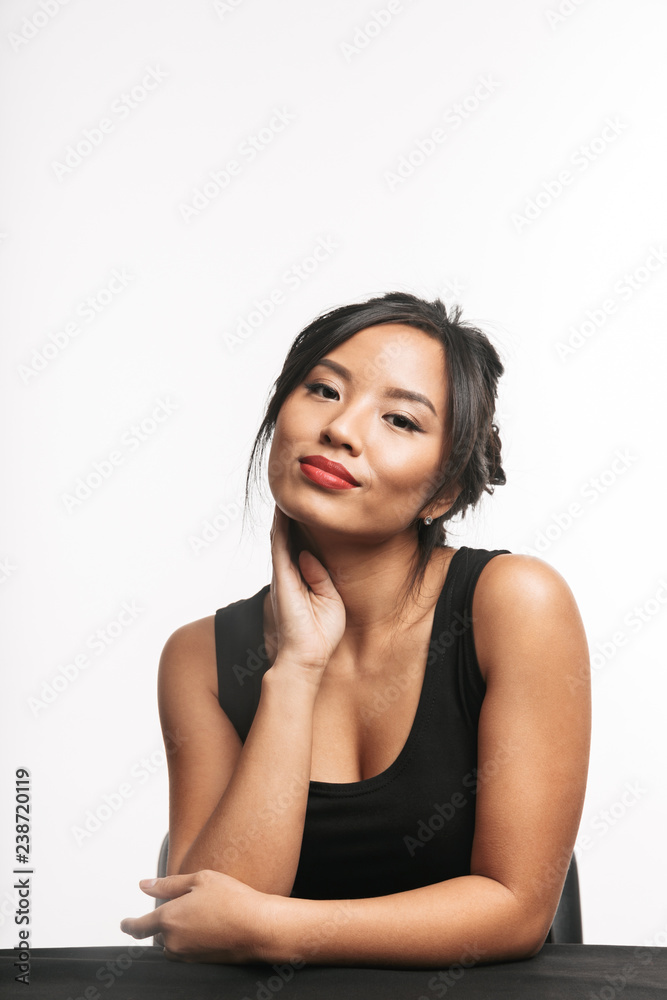 Poster Pretty young asian woman sitting at the table