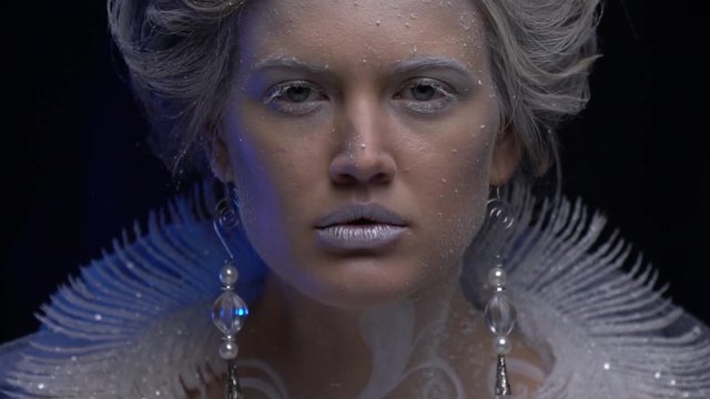 Icy snow queen opens up her eyes, slow motion