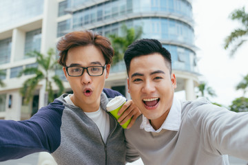 two handsome and young asian men making selfie portrait on smartphone in the airport - Image