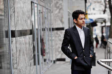 Young indian man on suit posed outdoor.