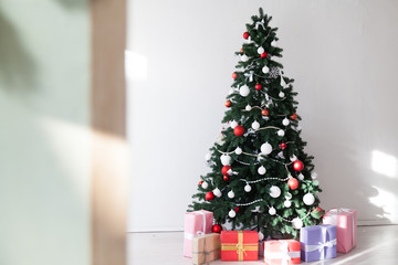 Christmas tree with lights garlands adorned with new year holiday gifts