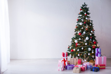 Christmas tree with lights garlands adorned with new year holiday gifts