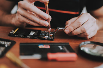 Close up Young Man Repairing Mobile Phone at Table