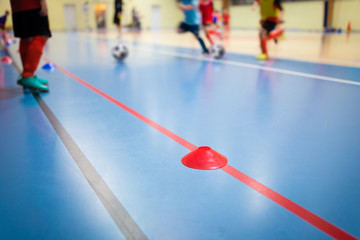 Obraz premium Group of Kids Training Indoor Soccer Futsal. Children Physical Education Class. Gym Class for Youth. Futsal Training Picture with Blurred Background