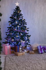 Christmas tree with lights garlands adorned with new year holiday gifts