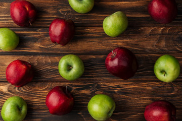 top view of ripe red and green apples on wooden table