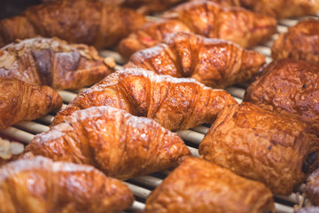 Delicious mouthwatering fresh puff pastry and croissants in bakery, closeup with copy space