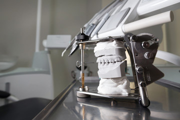 articulator and model of the jaw in the background Dental Equipment