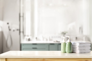 Ceramic shampoo, soap bottle and towels on counter over bathroom background. table top and copy...