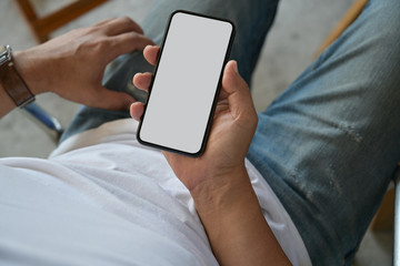 Top view shot of man holding blank screen mobile phone