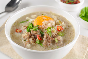 Congee with minced pork and boiled egg in bowl