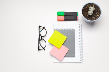 Sticky notes with markers, colored pens, paper clips laying on a table