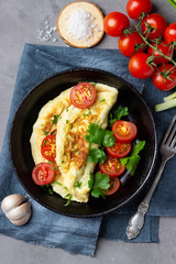 Omelette in frying pan on stone background. Top view.