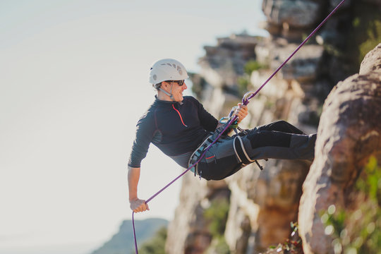 Man climbing mountain on sunny day