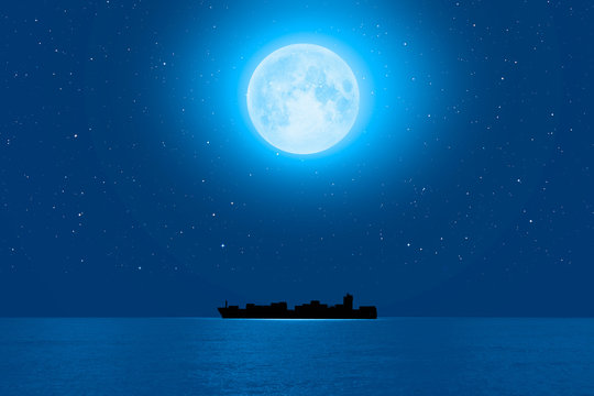 Silhouette of the cargo ship with super full moon (moonrise) "Elements of this image furnished by NASA"