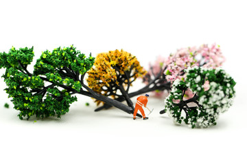 Miniature people : worker using a chainsaw to cut down a large beech tree, Deforestation concept.