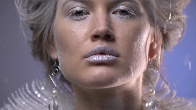 Close up of the woman with silver makeup, earrings and white collar