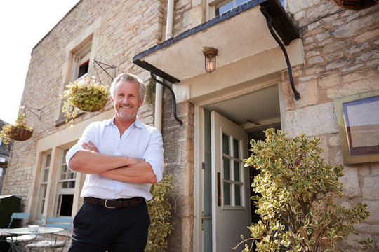 Senior Male Restaurant Pub Owner Stands Outside The Entrance