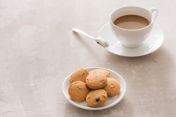 White cup of creamy coffee with butter cookies and stainless teaspoon isolated on white background, clipping path