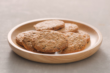 Oat cookies in plate isolated on white background, top view. Sweet bakery products. Round cookies in a wooden plate.