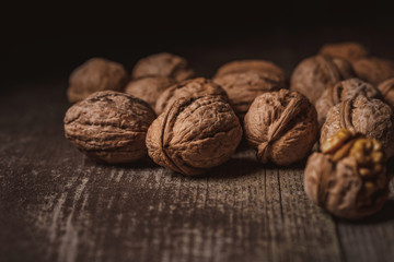 close up view of walnuts on wooden tabletop on black backdrop